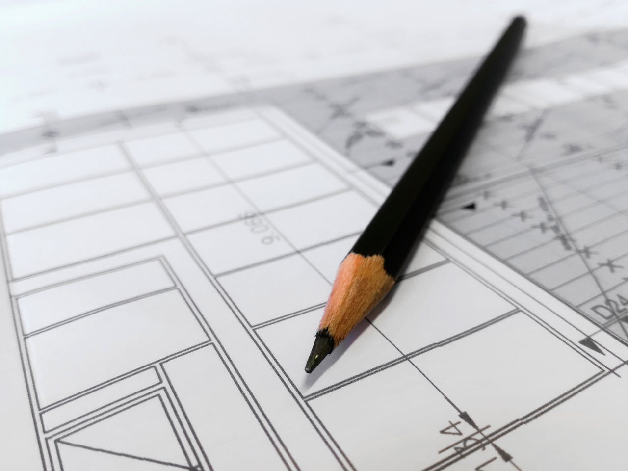 why-choose-us Detailed image of a black pencil resting on architectural blueprints, ideal for design and planning themes.